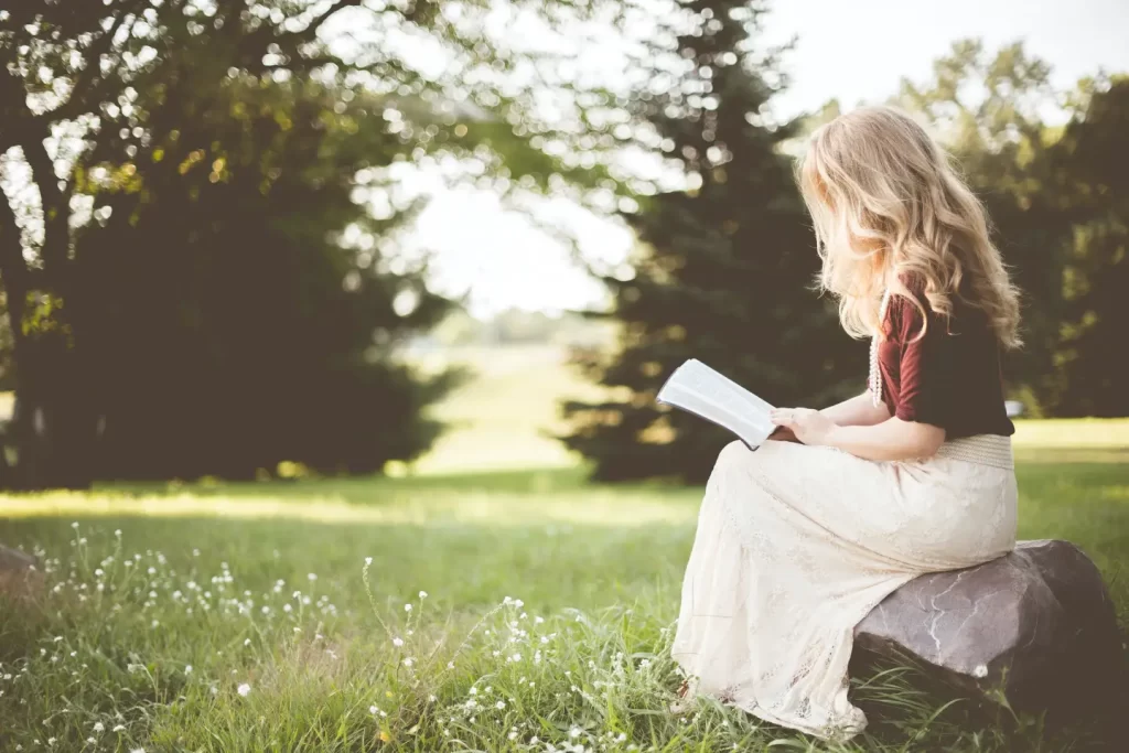 blonde-girl-reading-book-outside-garden