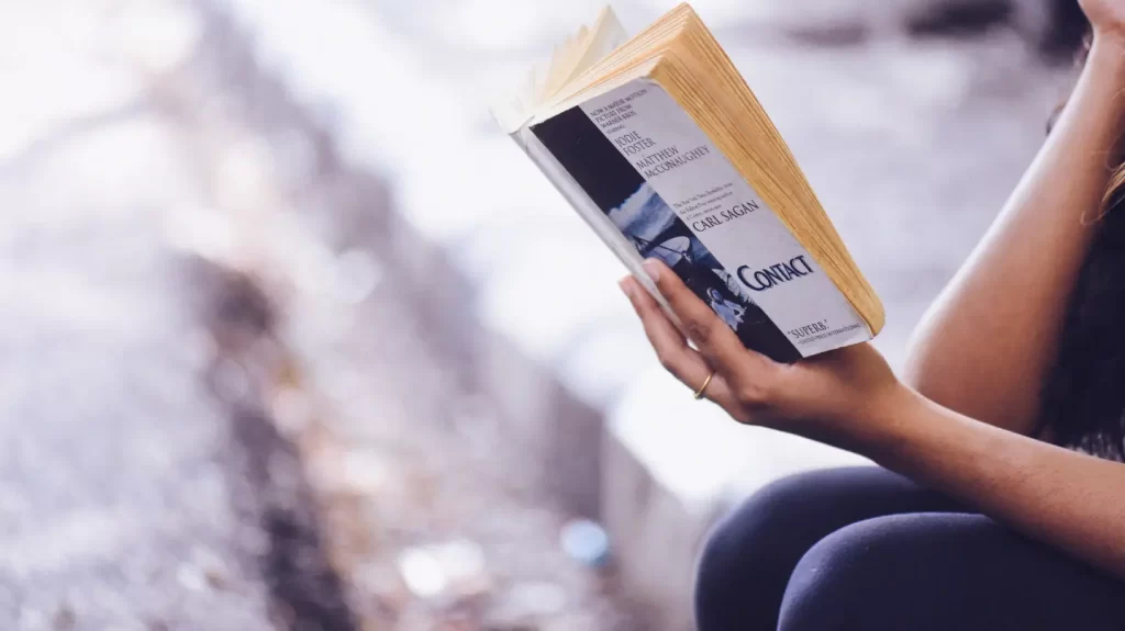 person-holding-book-side-street