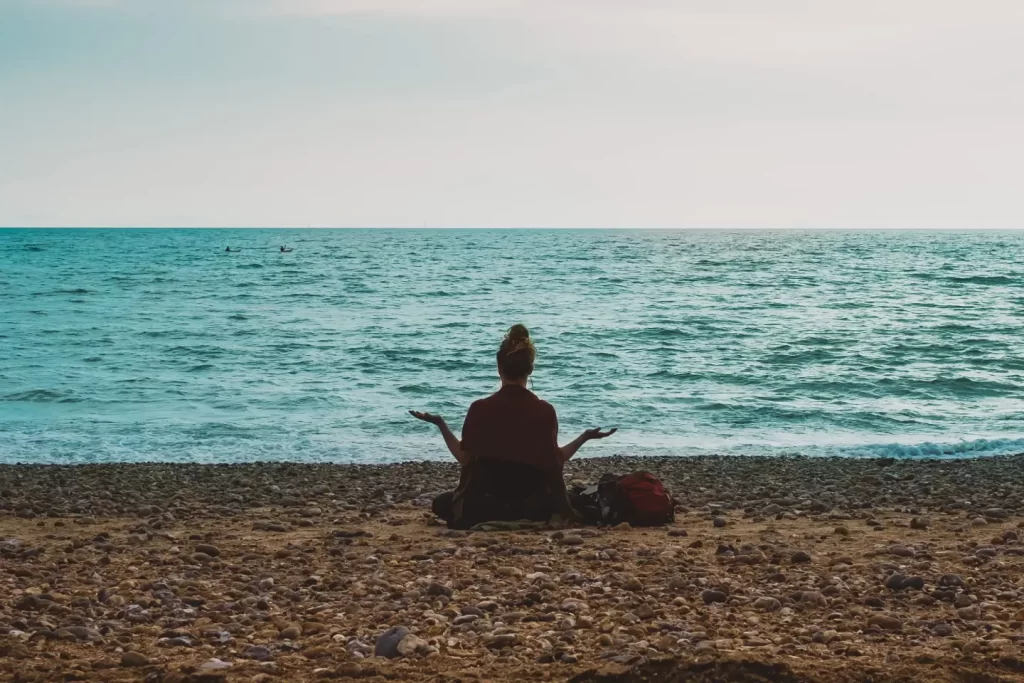 person-meditating-facing-sea