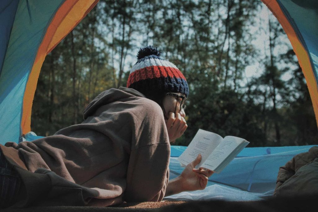 person-reading-inside-camping-tent