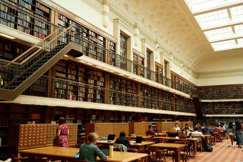 students-sitting-in-library-wall-of-books