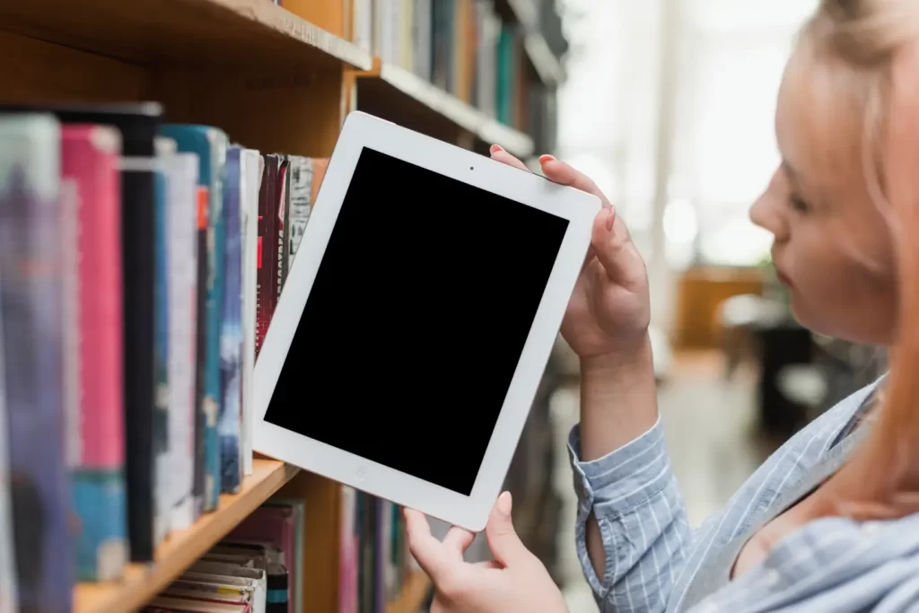 teenager-taking-tablet-from-bookshelf