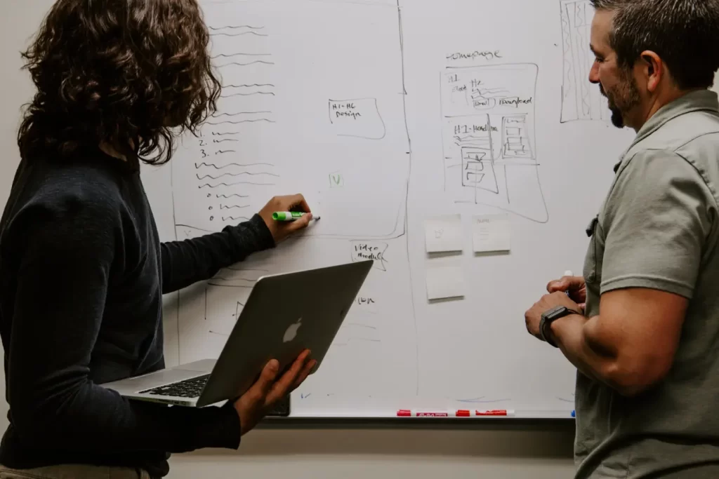 two-person-writing-plan-white-board