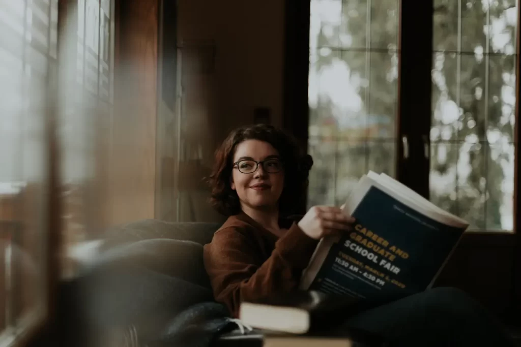 woman-looking-window-holding-big-book