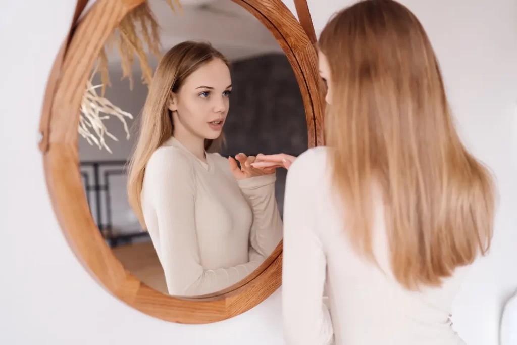 young-pretty-woman-home-look-mirror-enjoying-herself