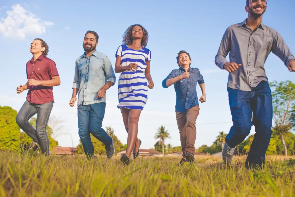 people-running-on-grassfield-under-blue-skies-at-daytime