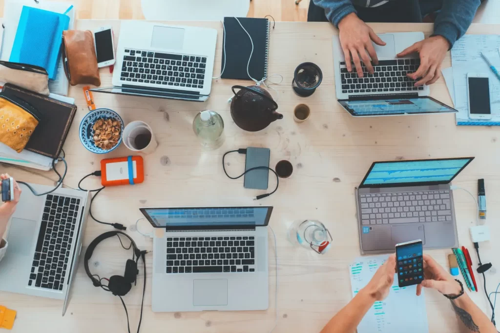 people-sitting-down-near-table-with-assorted-laptop-computers