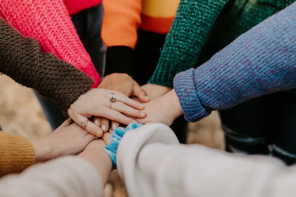 person-in-red-sweater-holding-babys-hand