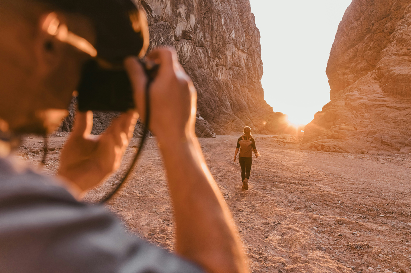 a-man-taking-a-picture-of-a-woman-in-the-desert