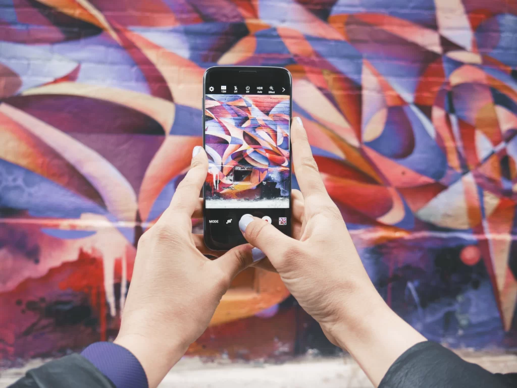 person-holding-android-smartphone-and-taking-a-photo-of-abstract-wall-during-daytime