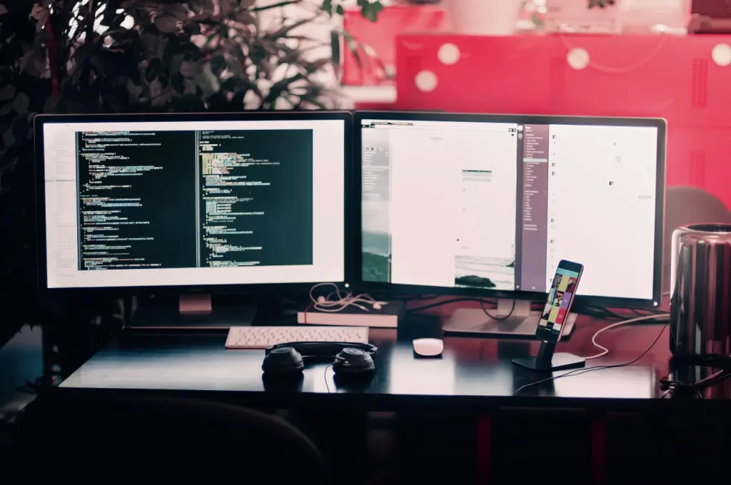 two-black-computer-monitors-on-black-table