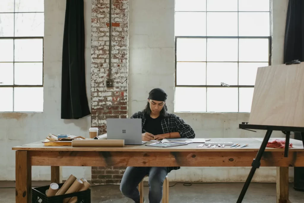 a-man-sitting-at-a-table-working-on-a-laptop