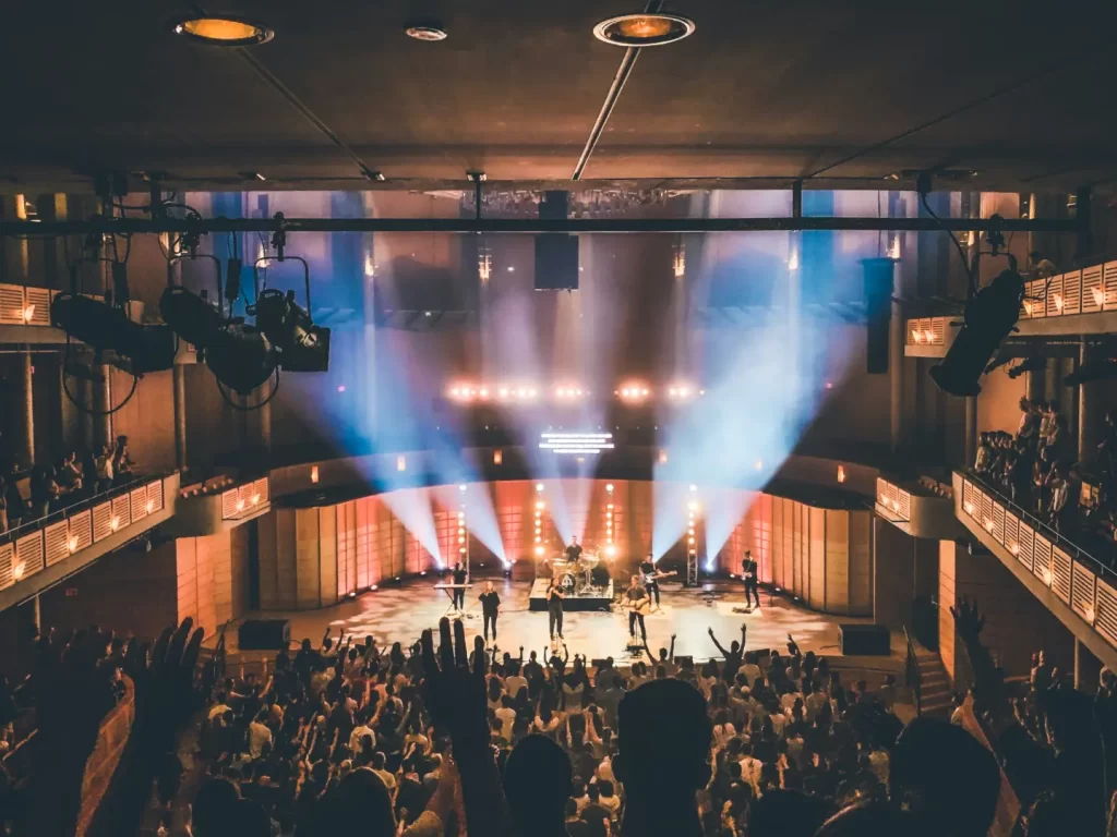 people-standing-on-stage-with-lights-turned-on-during-nighttime