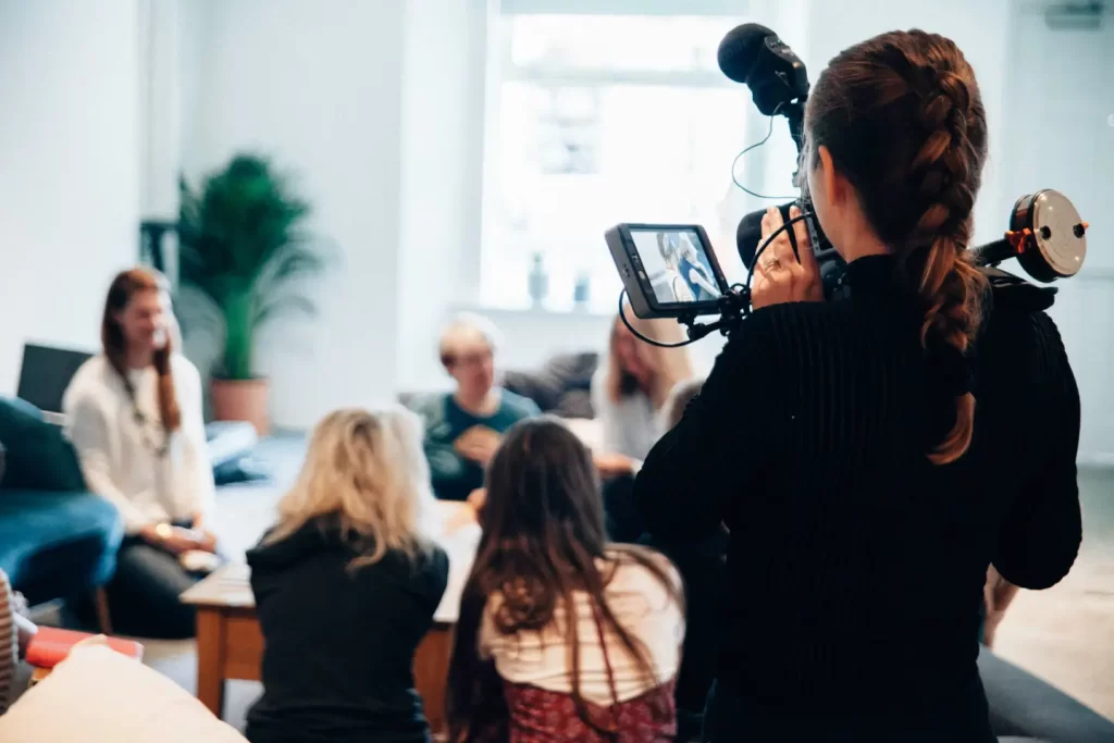 woman-holding-camera-standing-near-people