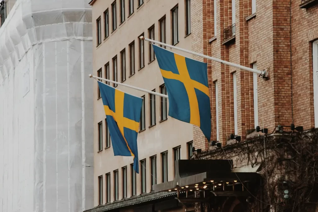 a-couple-of-flags-hanging-from-the-side-of-a-building