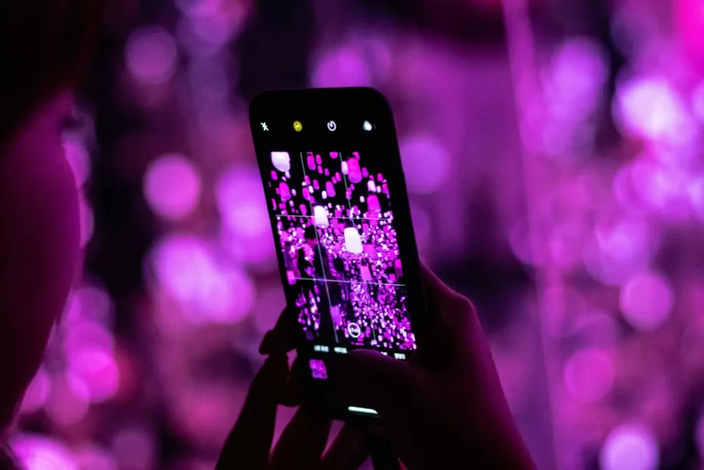 person-using-smartphone-capturing-violet-lights