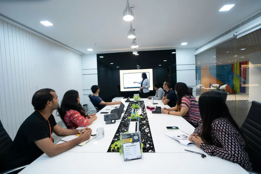 people-sitting-at-the-table-looking-to-another-person-standing-in-front-of-them